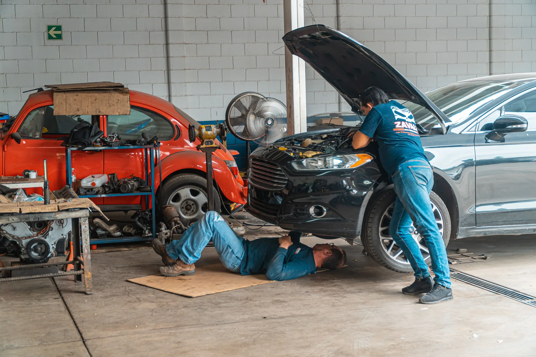 Mechaniker arbeitet in einer Werkstatt an einem Fahrzeug